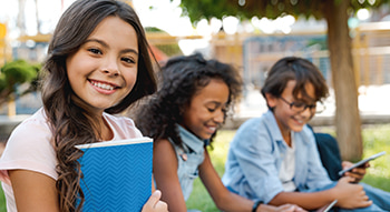 students sitting in the grass during a field trip